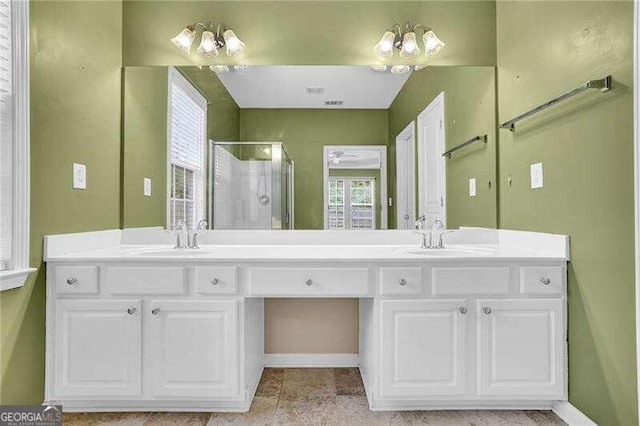 bathroom featuring vanity, a shower with door, and a healthy amount of sunlight