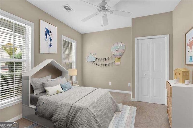 carpeted bedroom featuring ceiling fan and a closet