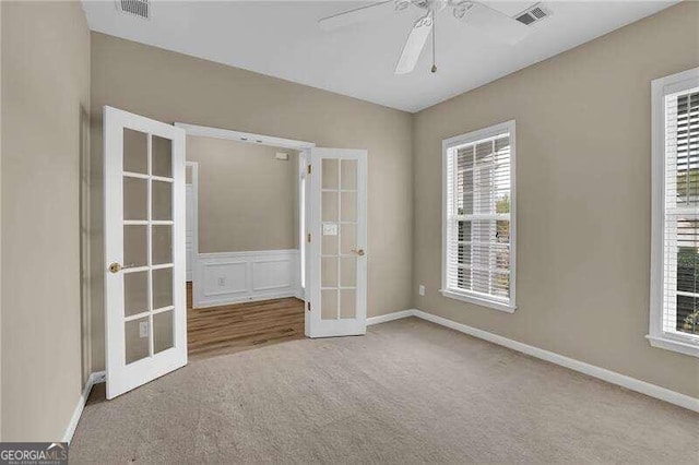 unfurnished room featuring french doors, carpet floors, and ceiling fan