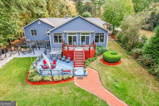 rear view of property with a deck, a patio, and a yard