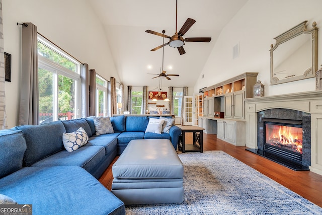 living room with ceiling fan, light wood-type flooring, and high vaulted ceiling