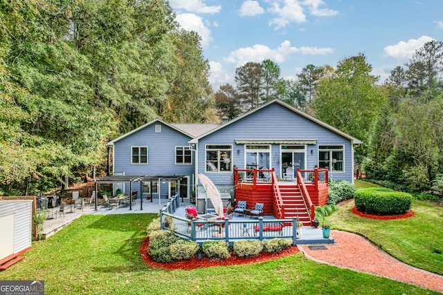 rear view of house featuring a yard and a deck