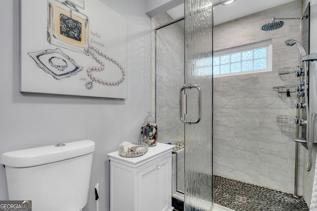 bathroom with toilet and a shower with shower door