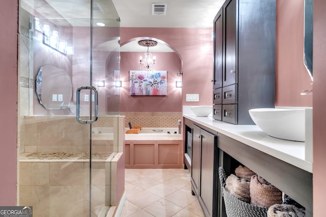 bathroom featuring tile patterned flooring, an inviting chandelier, backsplash, independent shower and bath, and vanity