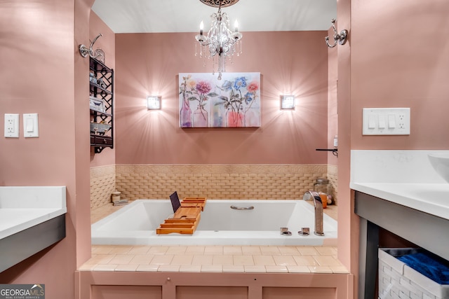 bathroom with a chandelier, vanity, and tiled tub