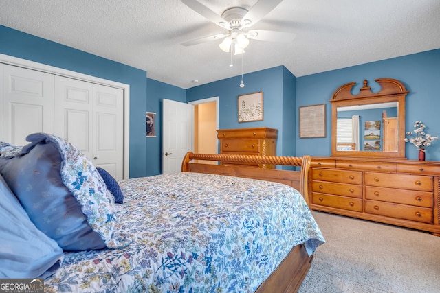 carpeted bedroom featuring ceiling fan, a textured ceiling, and a closet