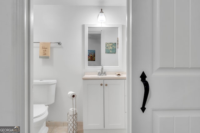 bathroom with tile patterned flooring, vanity, and toilet