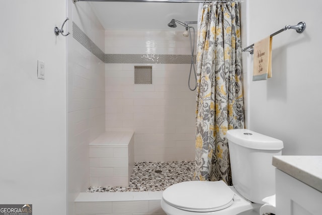 bathroom with curtained shower, vanity, and toilet