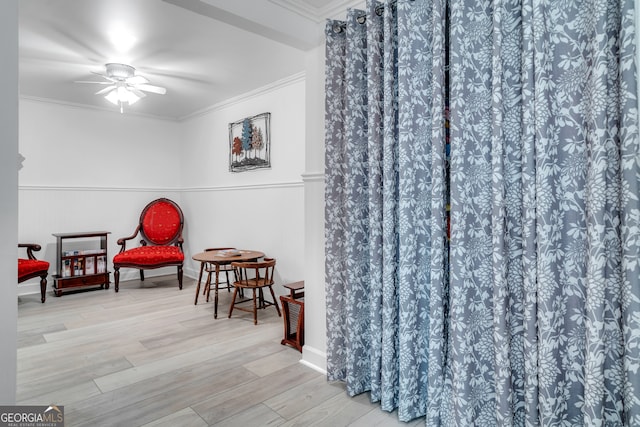 sitting room featuring ceiling fan, light hardwood / wood-style floors, and ornamental molding