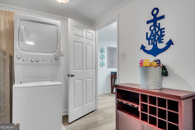 laundry room with stacked washer / dryer, light hardwood / wood-style flooring, and ornamental molding