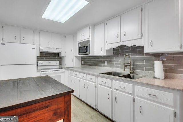 kitchen featuring white appliances, white cabinetry, sink, and light hardwood / wood-style floors