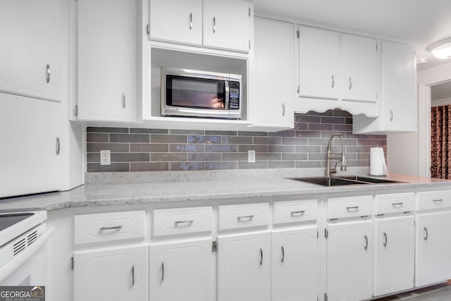 kitchen with white cabinetry, sink, and backsplash