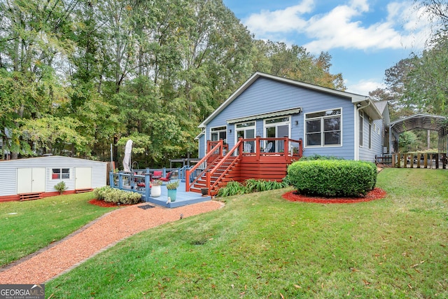 view of front of house with a deck, a front yard, and a storage shed