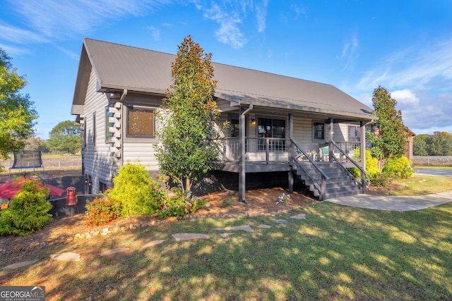 view of front of property with a porch, a front yard, and a trampoline