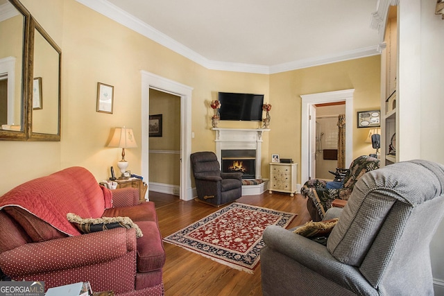 living room with a warm lit fireplace, dark wood-type flooring, ornamental molding, and baseboards