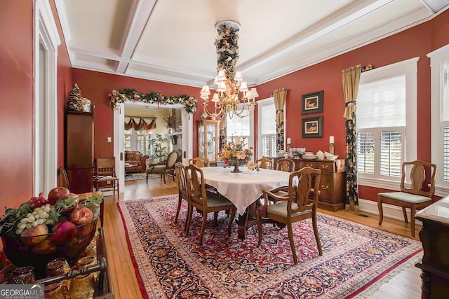 dining area with hardwood / wood-style flooring, plenty of natural light, beam ceiling, and a notable chandelier