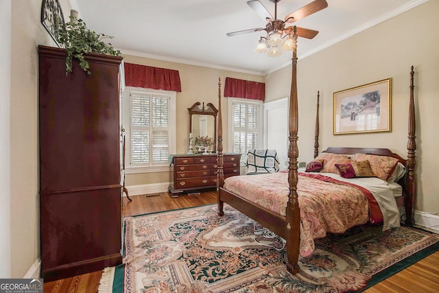 bedroom featuring ornamental molding, a ceiling fan, baseboards, and wood finished floors