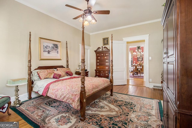 bedroom featuring ornamental molding, ceiling fan, baseboards, and wood finished floors