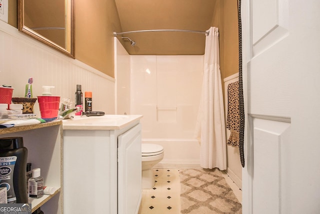 bathroom featuring a wainscoted wall, shower / bath combo, vanity, and toilet