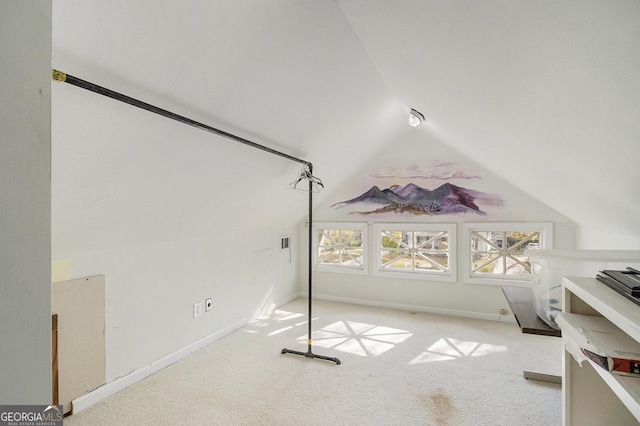 unfurnished bedroom with lofted ceiling, light colored carpet, and baseboards