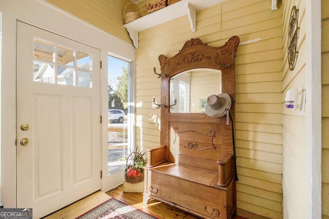 mudroom with wooden walls and wood finished floors