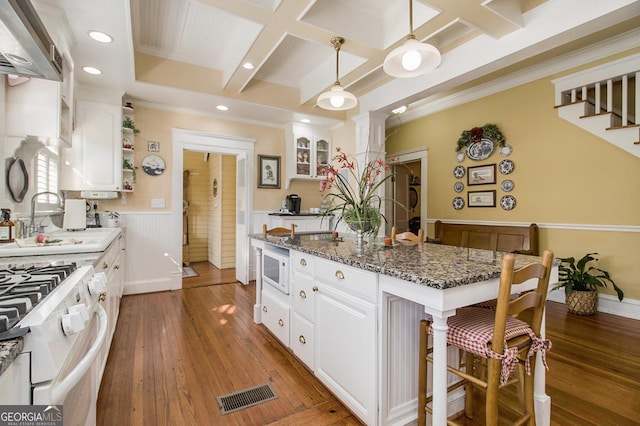 kitchen featuring pendant lighting, visible vents, white cabinets, dark stone countertops, and coffered ceiling