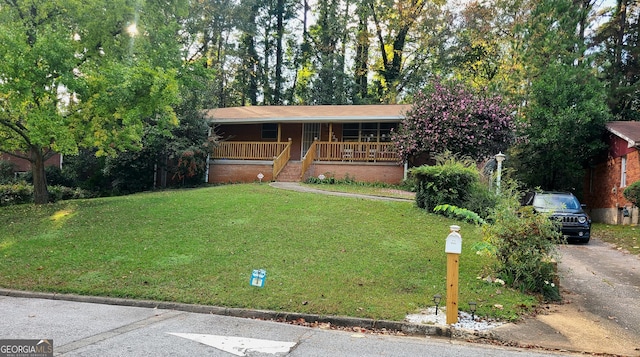 ranch-style home with covered porch, driveway, and a front lawn