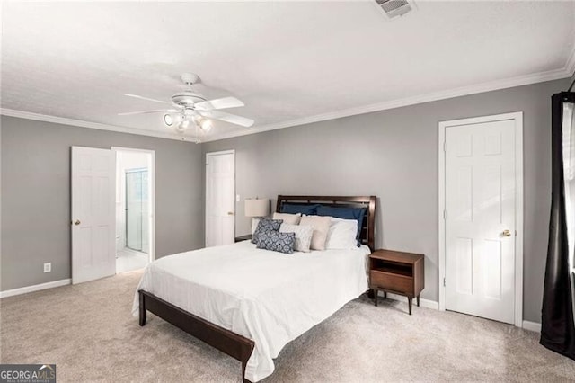 carpeted bedroom with ensuite bathroom, ceiling fan, and crown molding