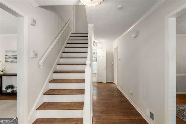 stairs featuring hardwood / wood-style flooring and crown molding