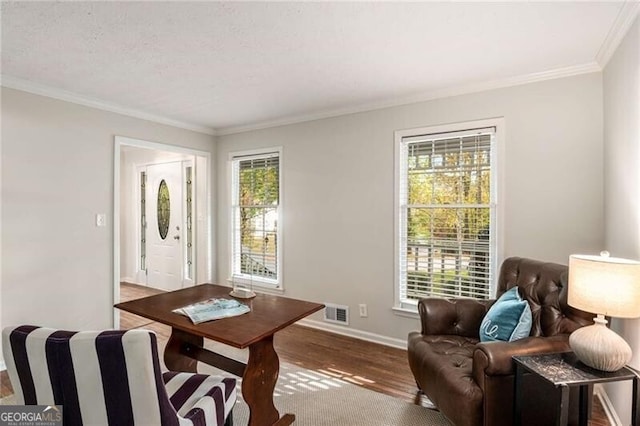 sitting room with hardwood / wood-style floors and crown molding