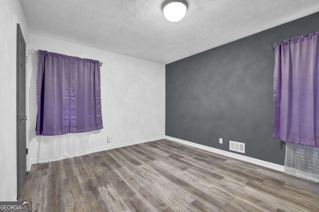 2611 Kings Cir, Lawrenceville, GA 30044 - empty room with wood finished floors, a textured ceiling, and baseboards