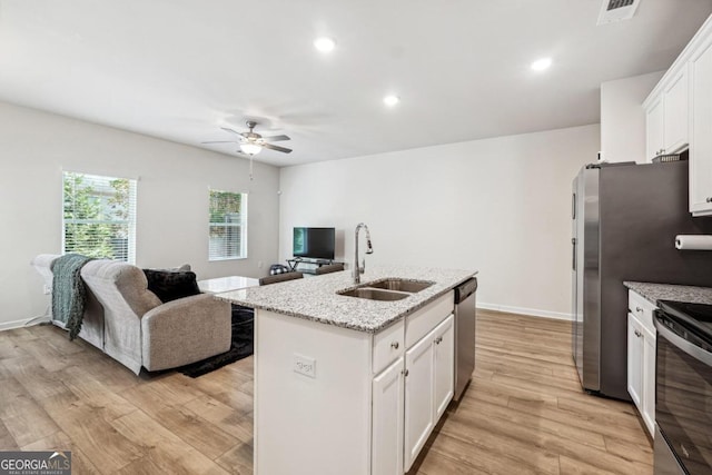 kitchen featuring white cabinetry, sink, a kitchen island with sink, and light hardwood / wood-style flooring