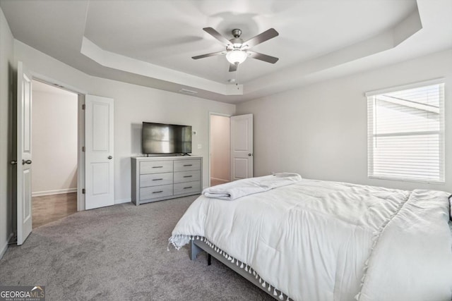 bedroom featuring a tray ceiling, ceiling fan, and carpet floors