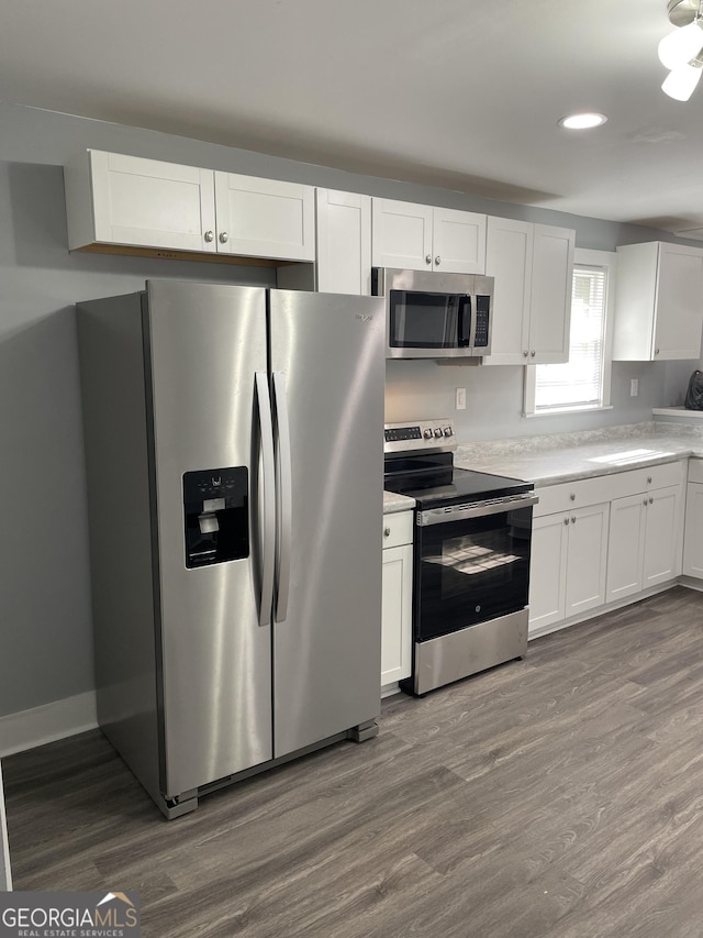 kitchen featuring hardwood / wood-style floors, white cabinets, and appliances with stainless steel finishes