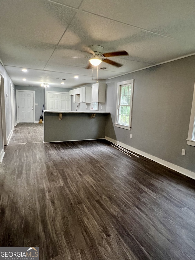 unfurnished living room with ceiling fan and dark hardwood / wood-style flooring