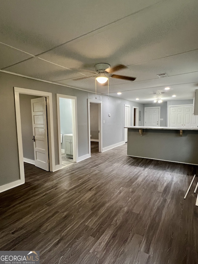 unfurnished living room featuring dark hardwood / wood-style flooring, a textured ceiling, and ceiling fan