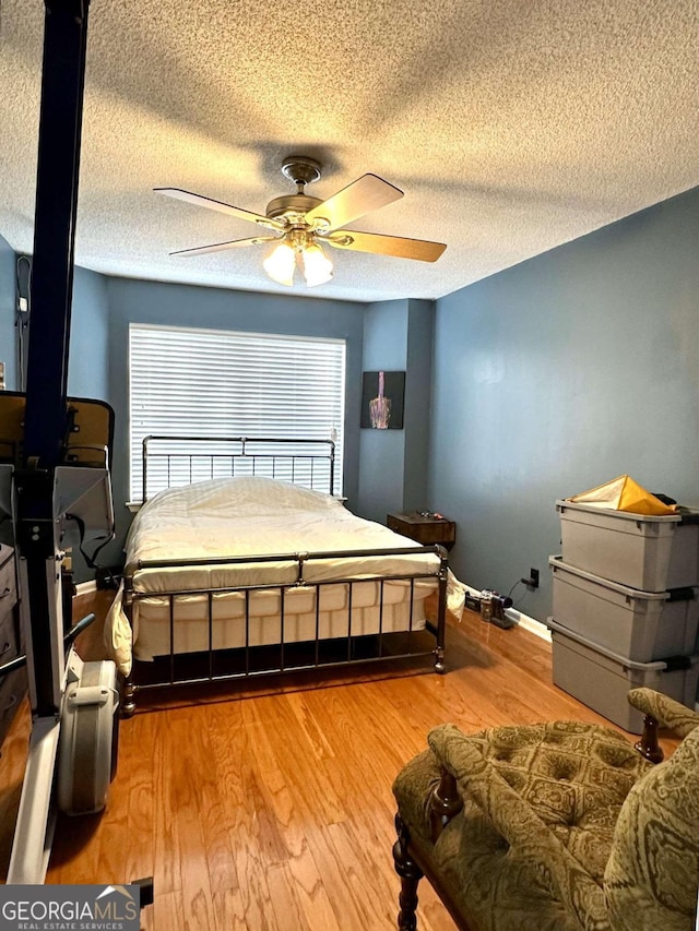 bedroom featuring a textured ceiling, light hardwood / wood-style flooring, and ceiling fan