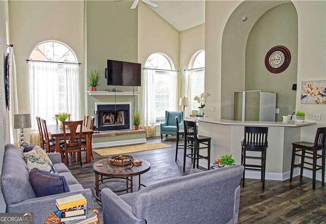 living room with ceiling fan, a wealth of natural light, high vaulted ceiling, and dark hardwood / wood-style flooring