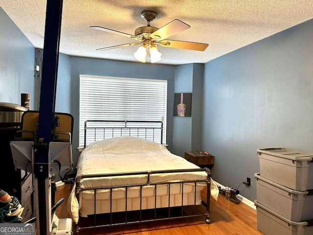 bedroom featuring ceiling fan, a textured ceiling, and light hardwood / wood-style flooring