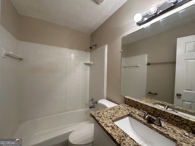 full bathroom featuring vanity, a textured ceiling, toilet, and tiled shower / bath