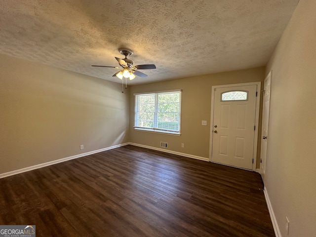 foyer entrance with a textured ceiling, dark hardwood / wood-style floors, and ceiling fan