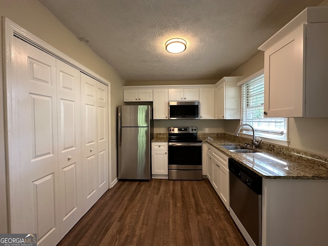 kitchen featuring sink, appliances with stainless steel finishes, a textured ceiling, and white cabinets