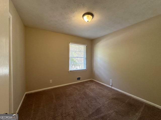 spare room with a textured ceiling and carpet floors