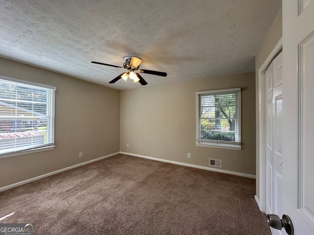 carpeted empty room with a textured ceiling and ceiling fan