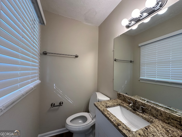 bathroom with vanity, a textured ceiling, and toilet