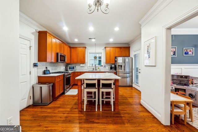 kitchen featuring a kitchen breakfast bar, stainless steel appliances, dark hardwood / wood-style floors, and a center island