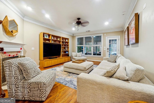 living room featuring wood-type flooring, ceiling fan, and crown molding