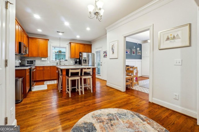 kitchen featuring stainless steel appliances, dark wood-type flooring, a breakfast bar area, and a center island