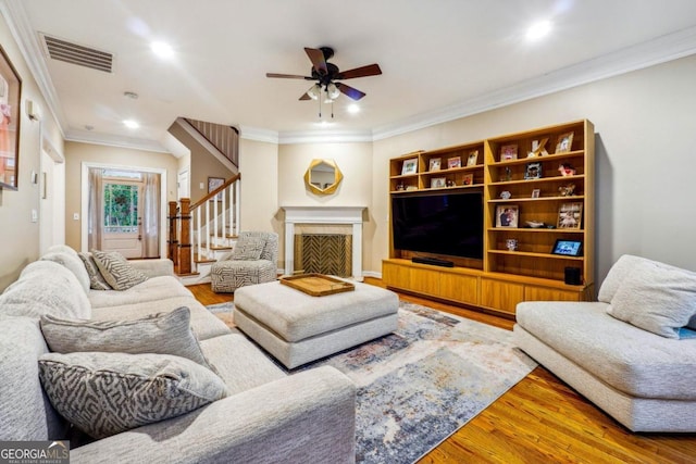 living room with ornamental molding, hardwood / wood-style floors, and ceiling fan