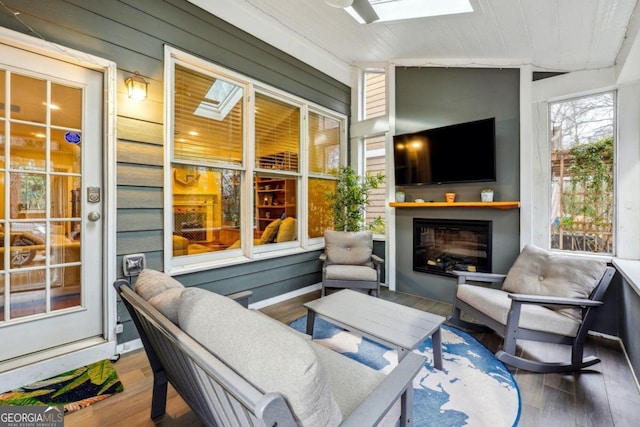 sunroom with wood ceiling and vaulted ceiling with skylight